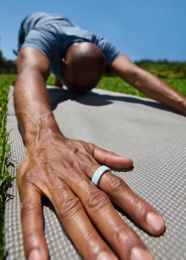 A person wearing an Oura Ring 4 Ceramic in Tide finish
