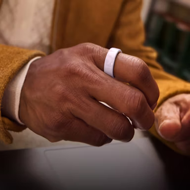 Close up of a person's hand with a Petal Oura Ring 4 Ceramic on their finger