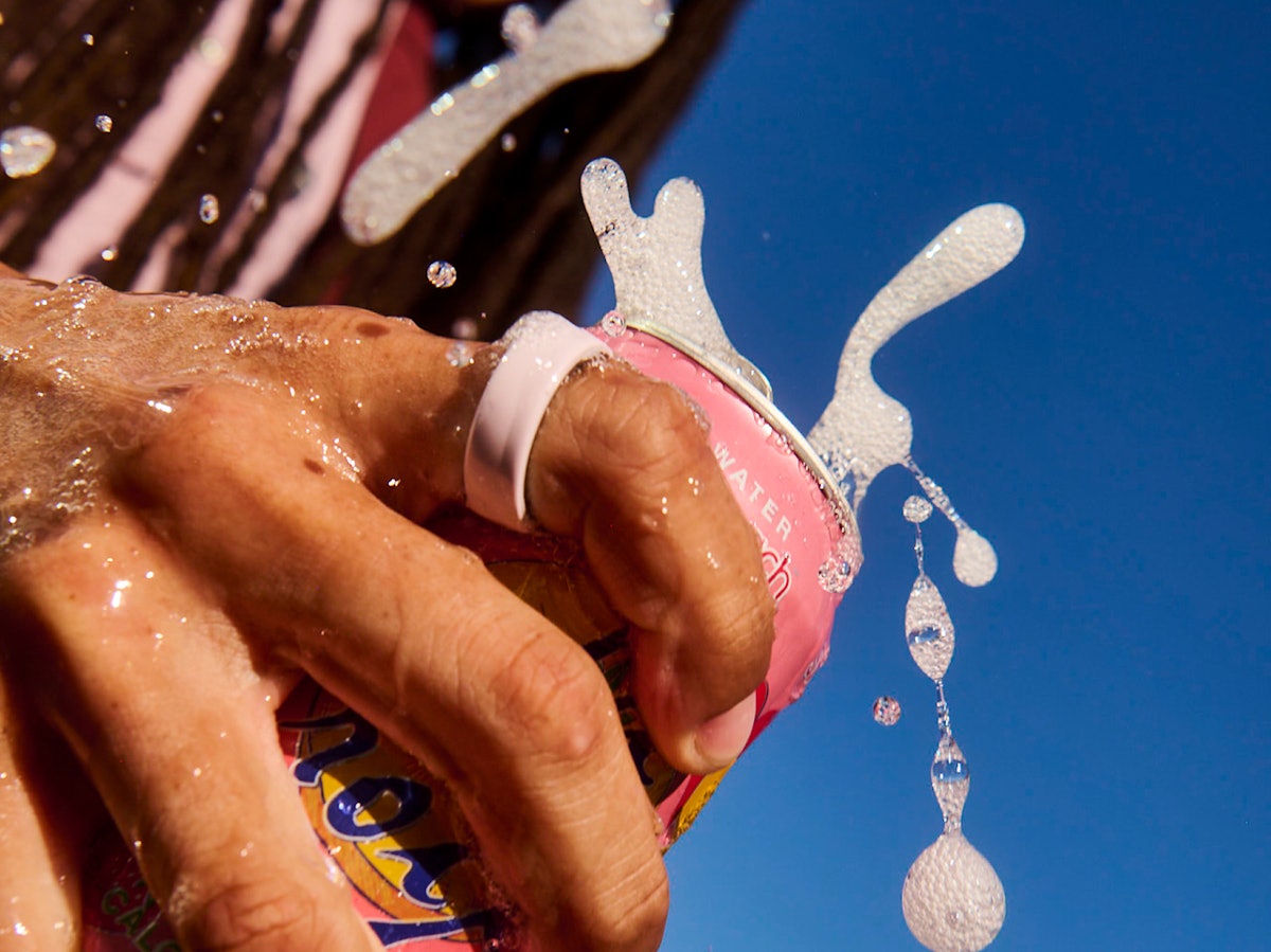 Close up of a person's hand with a Petal Oura Ring 4 Ceramic on their finger