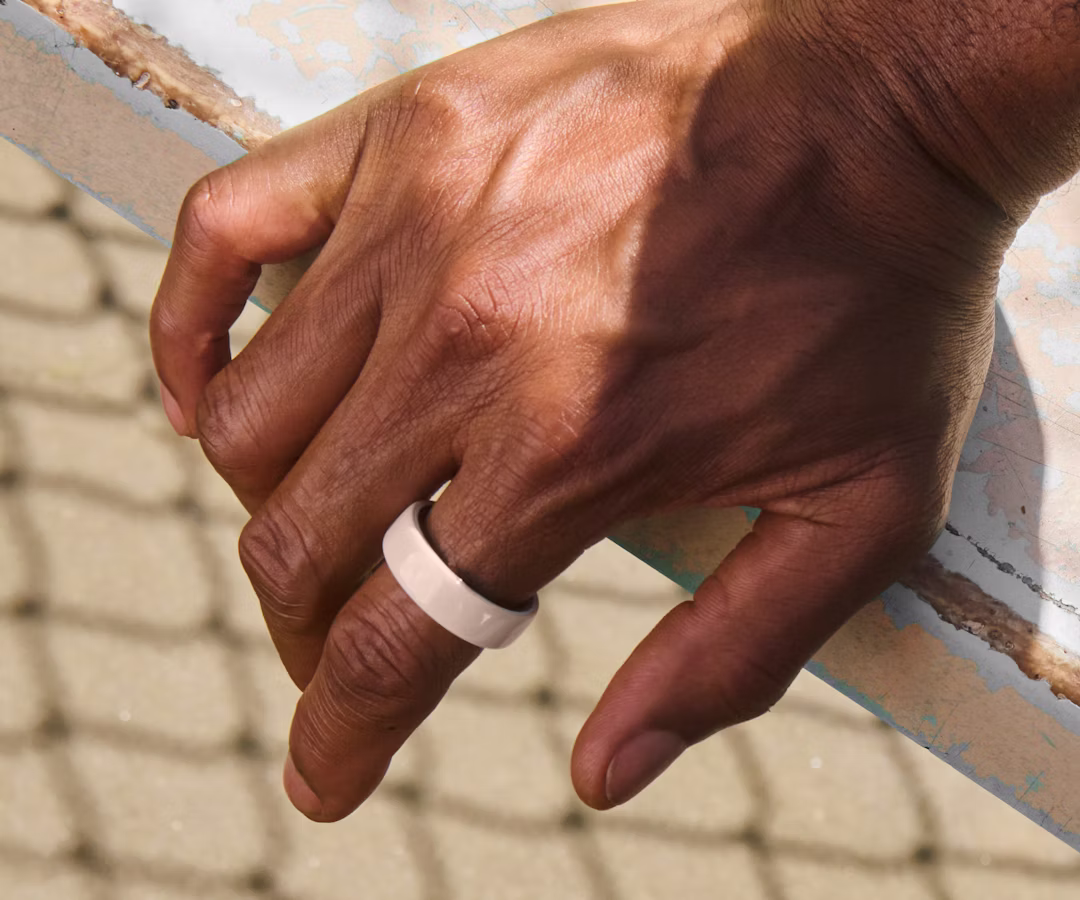 Close up of a person's hand with a Cloud Oura Ring 4 Ceramic on their finger