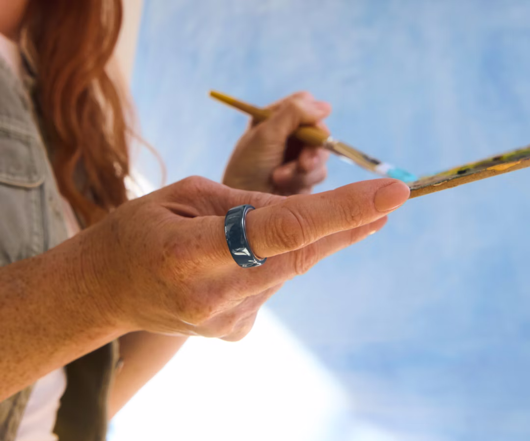 Close up of a person's hand with a Midnight Oura Ring 4 Ceramic on their finger