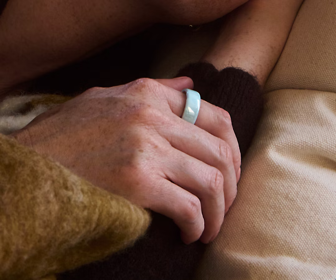 Close up of a person's hand with a Tide Oura Ring 4 Ceramic on their finger