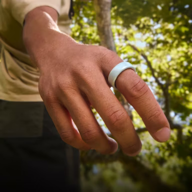 Close up of a person's hand with a Tide Oura Ring 4 Ceramic on their finger